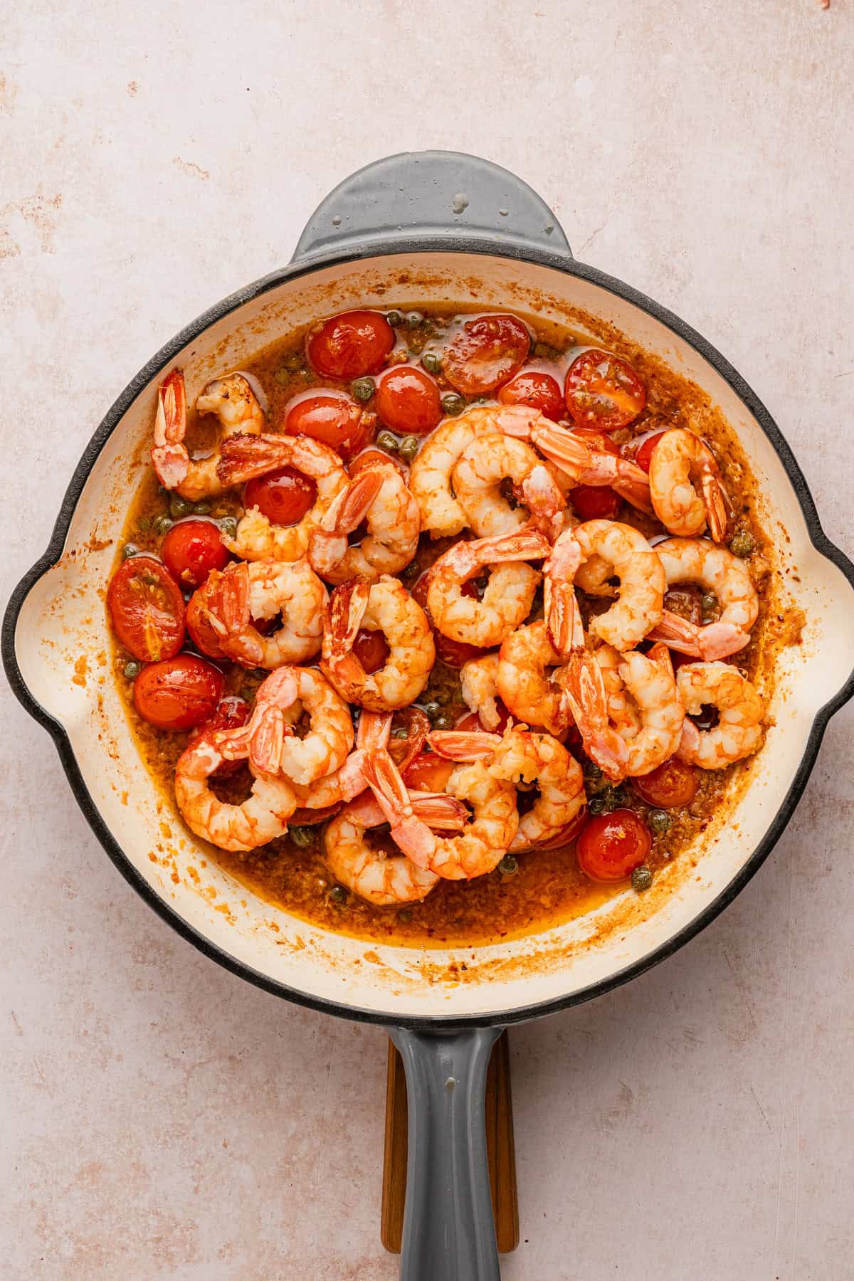 Adding shrimp to white wine sauce.