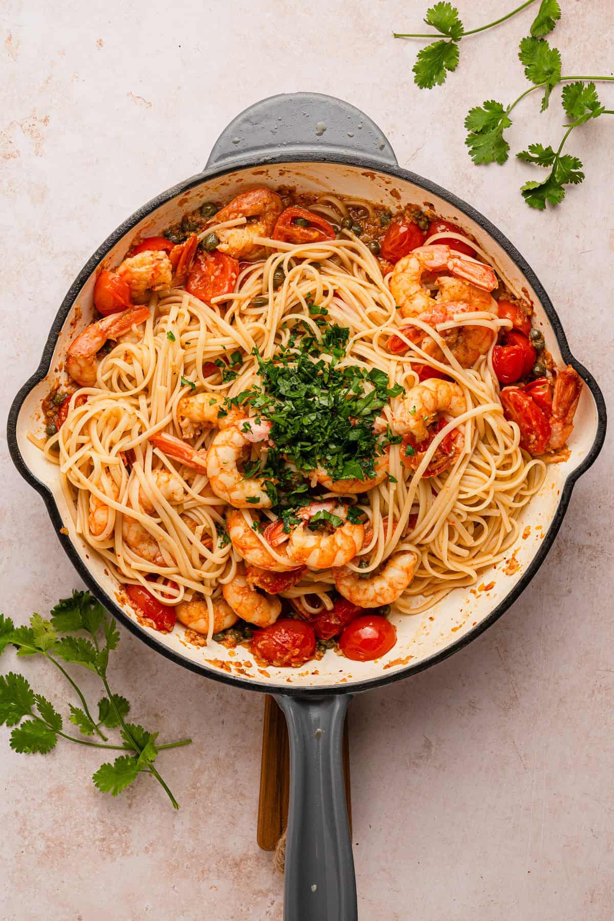 Adding pasta and parsley to sauce.