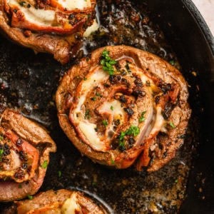 A cooked beef pinwheel in a cast iron skillet.