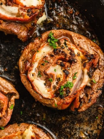 A cooked beef pinwheel in a cast iron skillet.