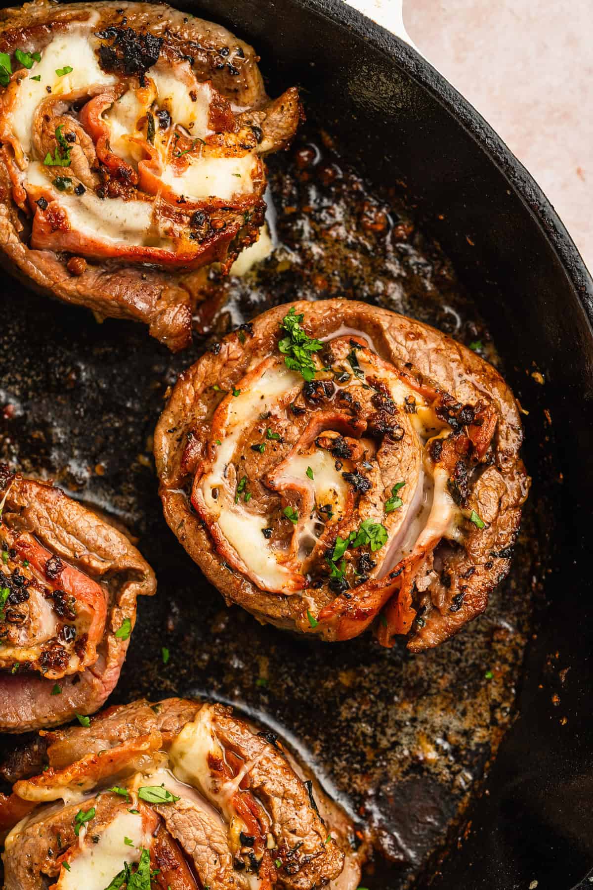 Complete beef pinwheels in a cast iron skillet.