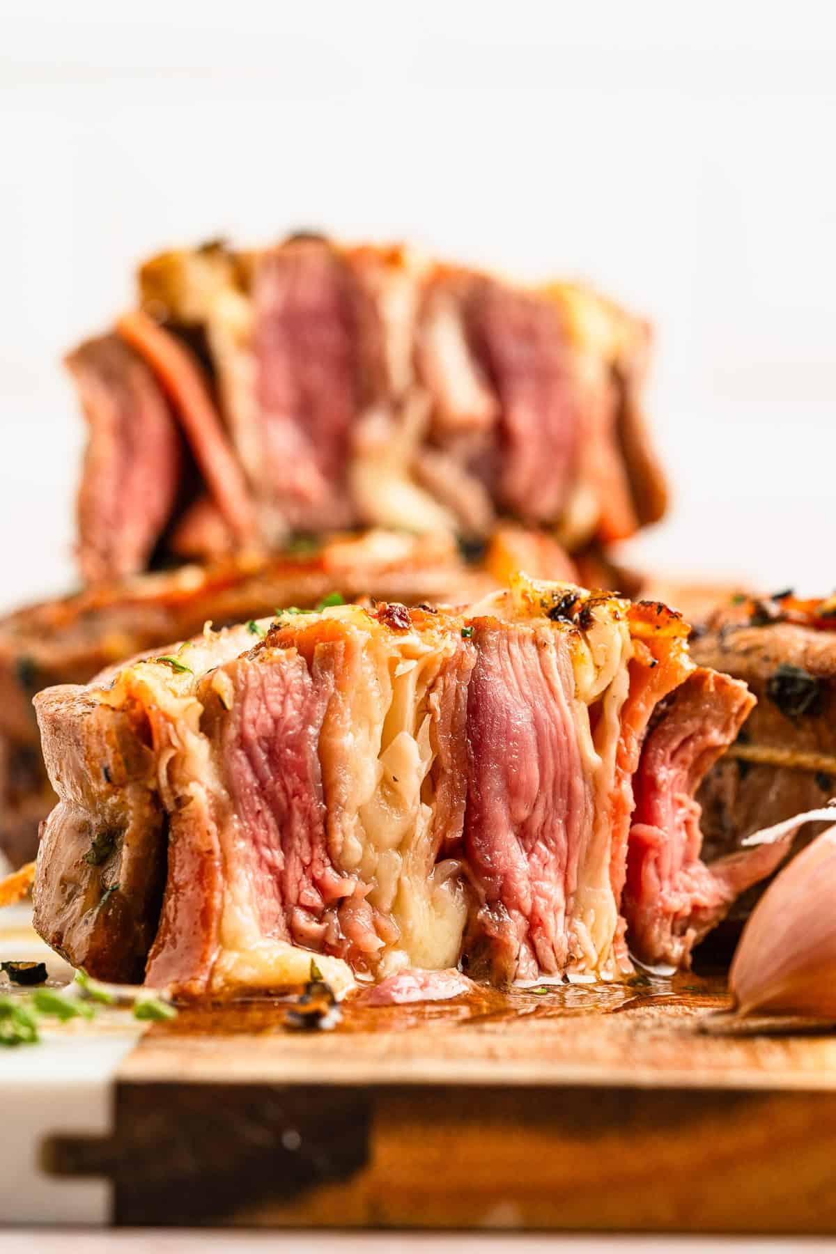 Beef pinwheel cut in half on a cutting board.