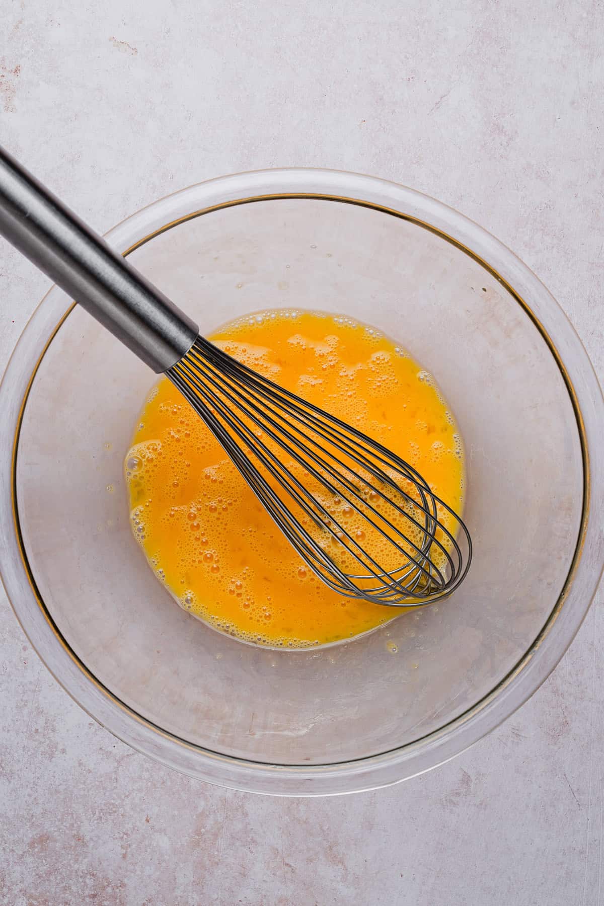 Beating eggs with a whisk.