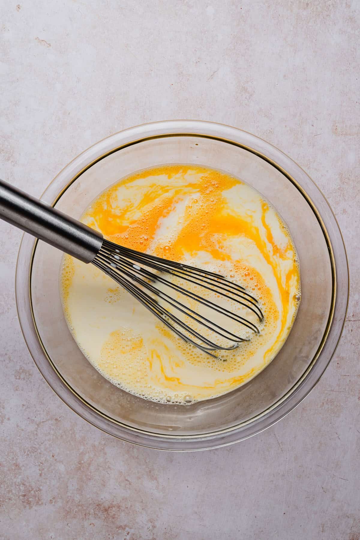 Mixing flan custard with a whisk.