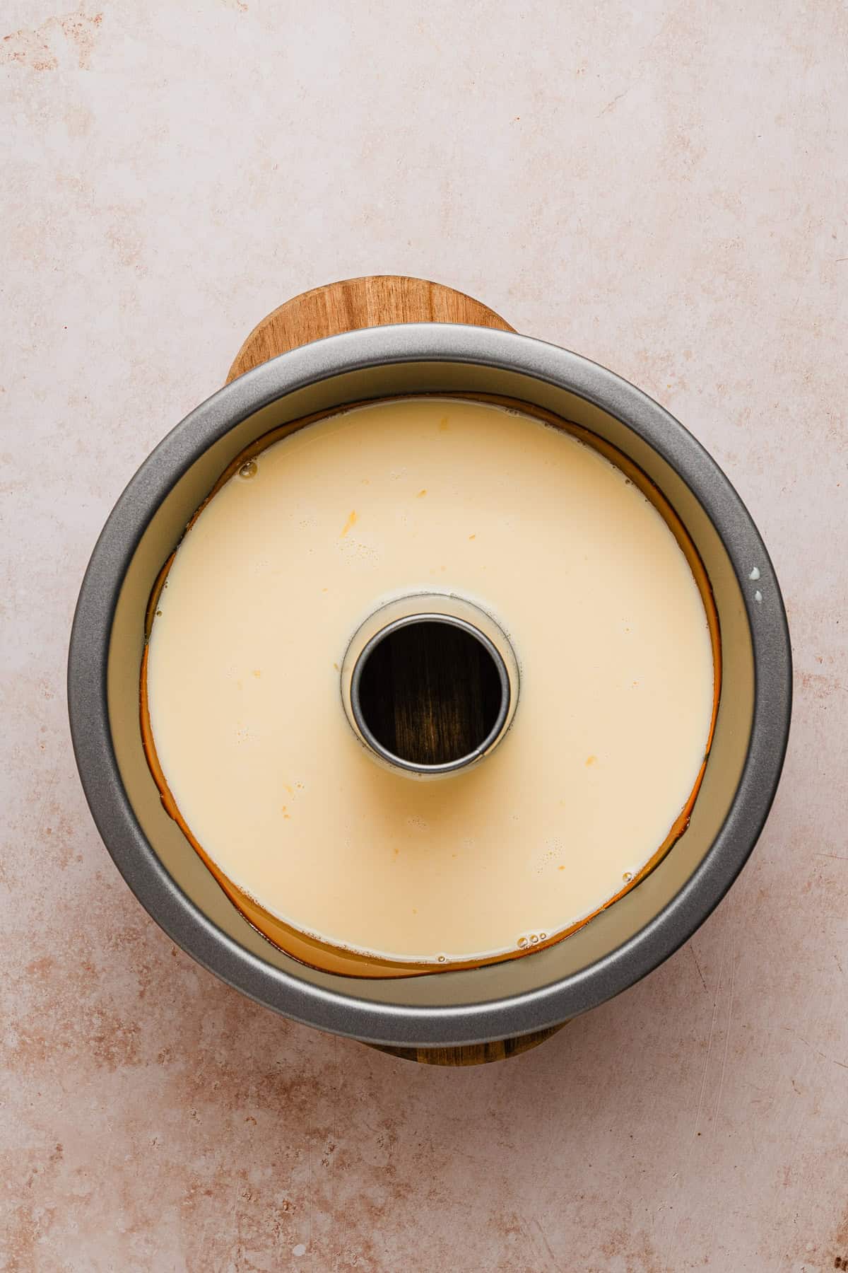 Custard poured over caramel in tube pan.