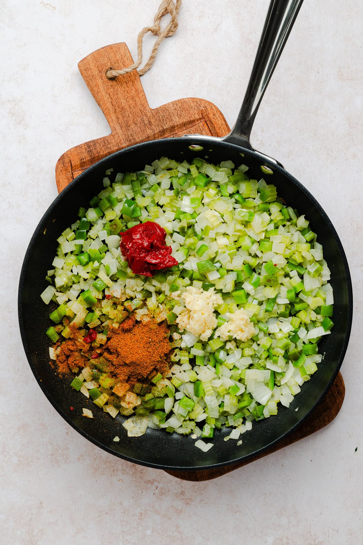 Cooking the vegetables and seasonings to make the sauce.
