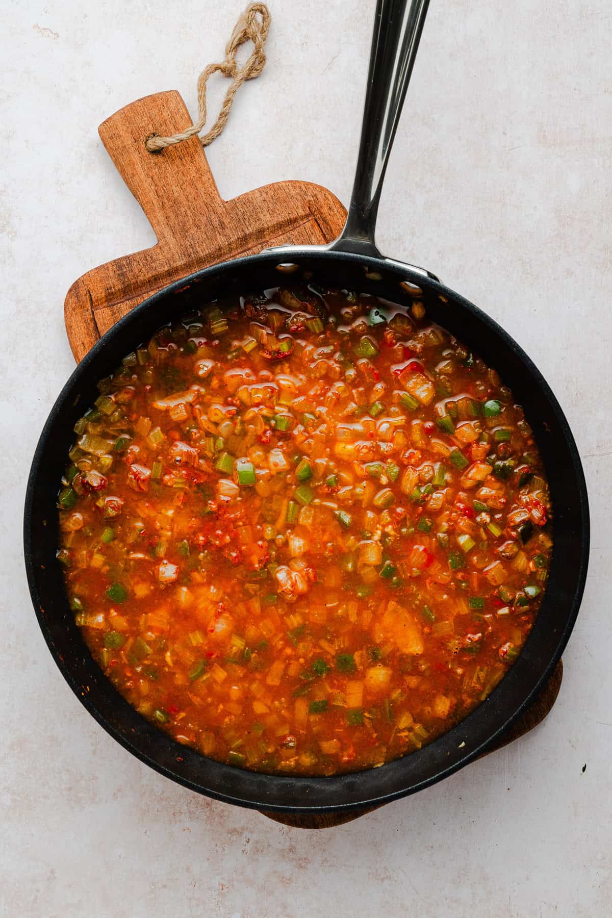 Adding some chicken broth and tomato paste to make the pasta sauce.