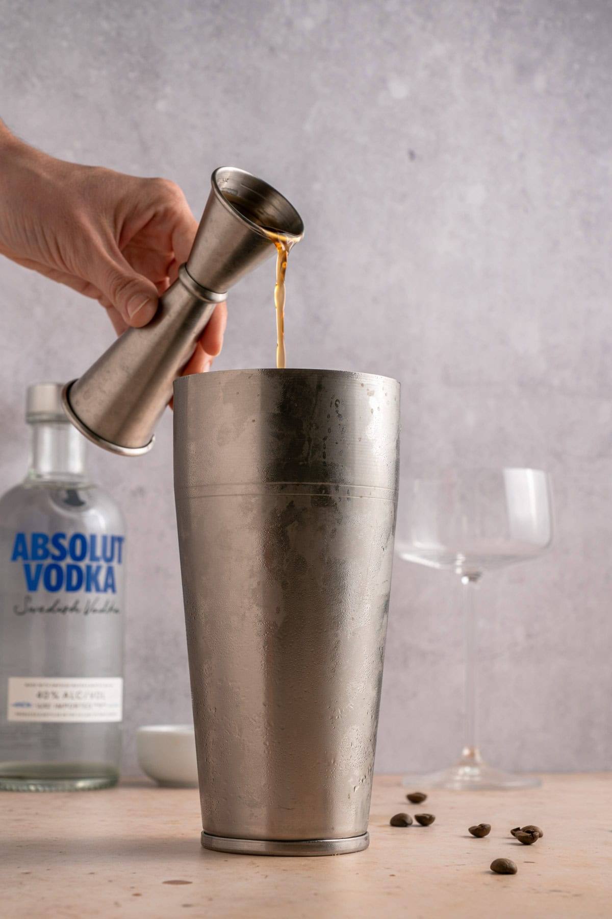 Adding coffee liqueur to cocktail shaker.