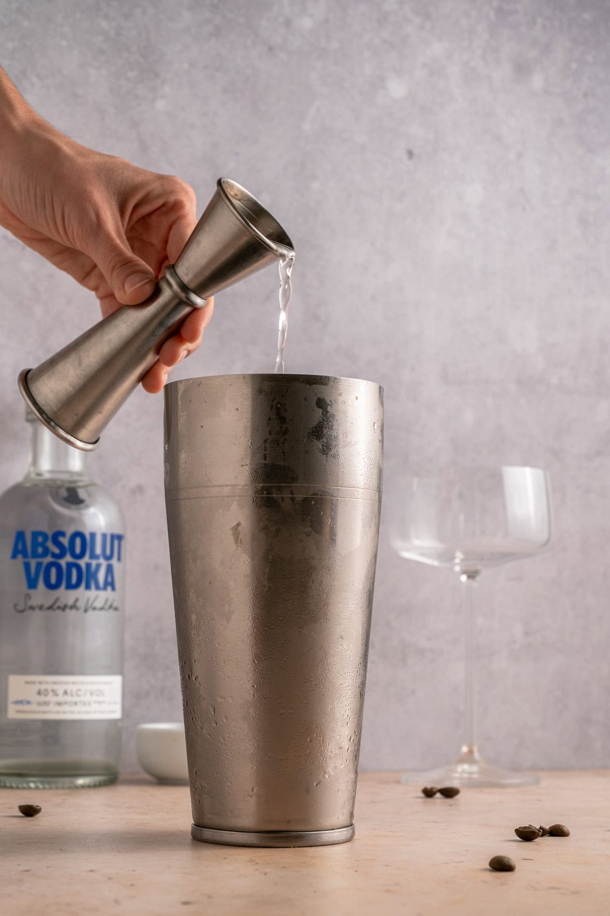 Adding vodka to a cocktail shaker.