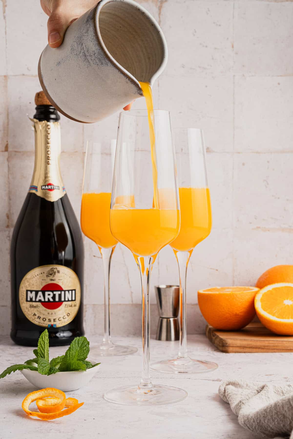 Adding orange juice to glass.