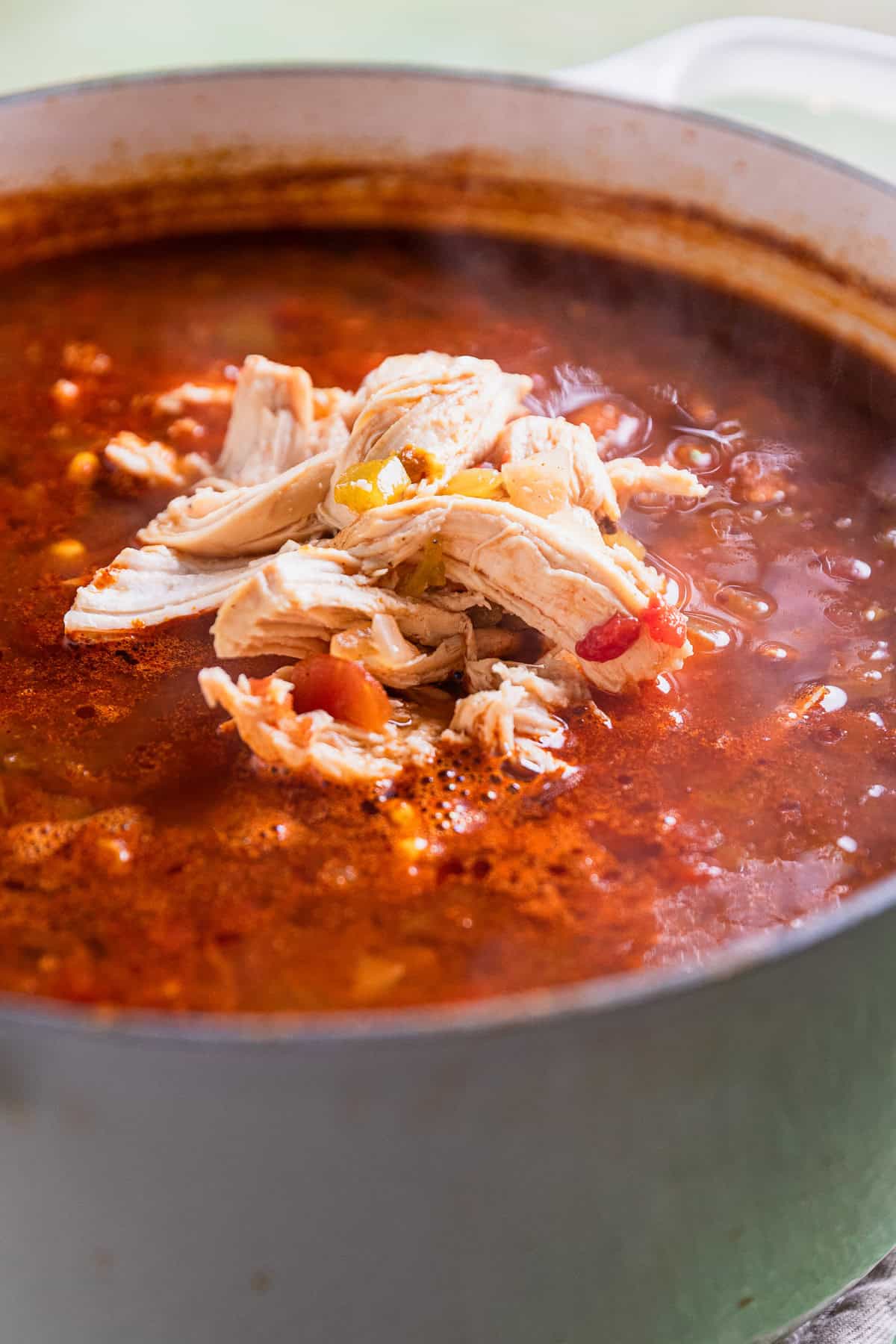 Shredded chicken in the soup pot.