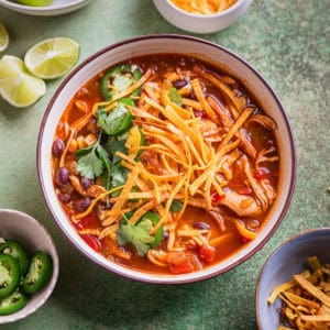 Chicken tortilla soup in bowl with garnishes.