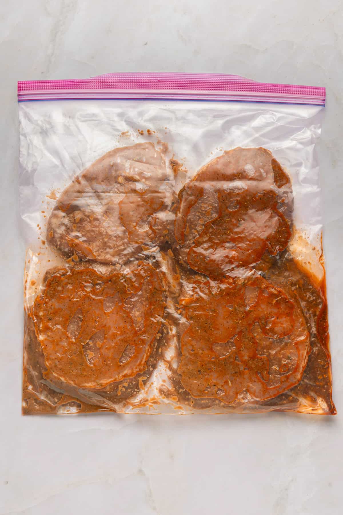 Marinated pork chops in a ziplock bag.
