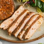 Air fryer honey garlic pork chops sliced on a plate.