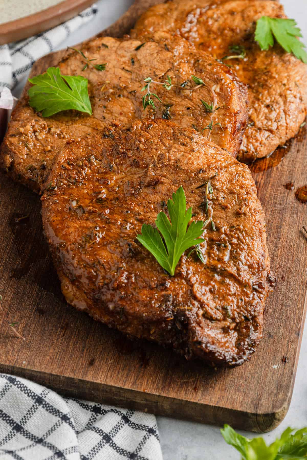Air fryer pork chops on a cutting board.