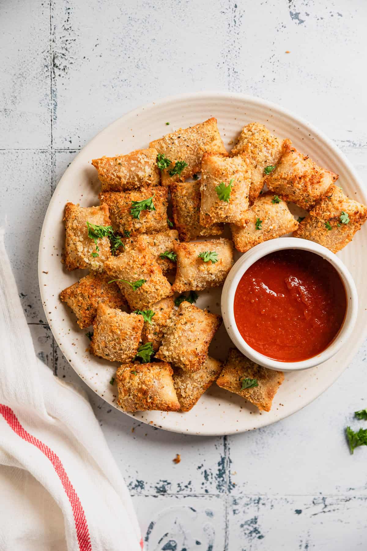 Totino's pizza rolls with breadcrumb coating on a plate with dipping sauce.