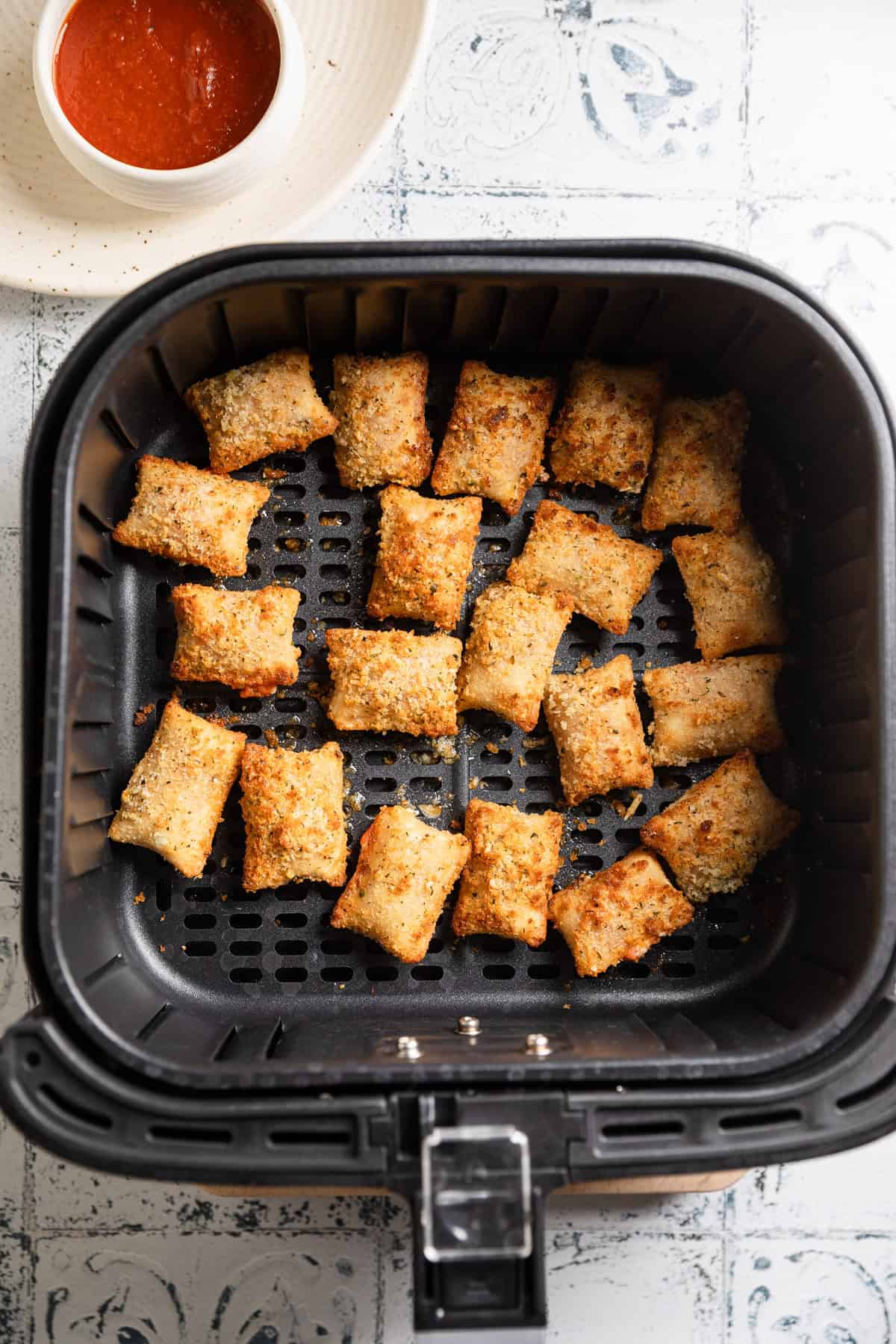 Pizza rolls in air fryer basket.