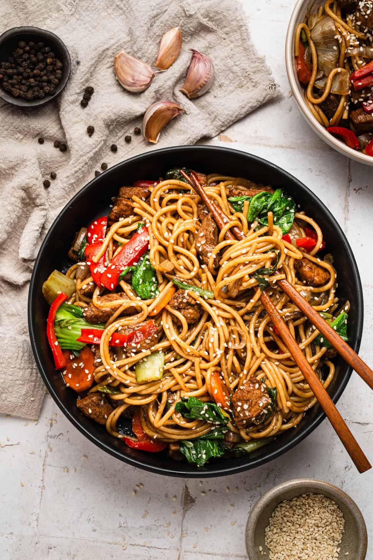 Lo mein with pork and vegetables cooked in the instant pot and served in a bowl with chopsticks.