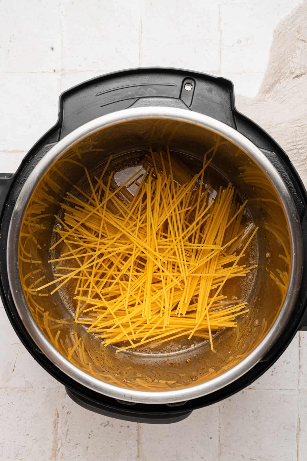 Using a criss cross pattern to place the dry noodles in the instant pot.