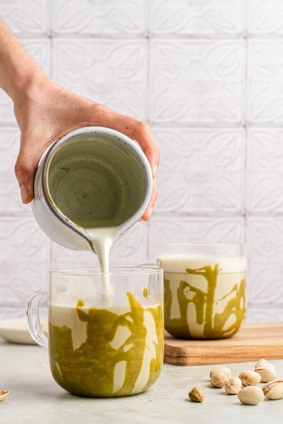 Adding warmed milk to mug.