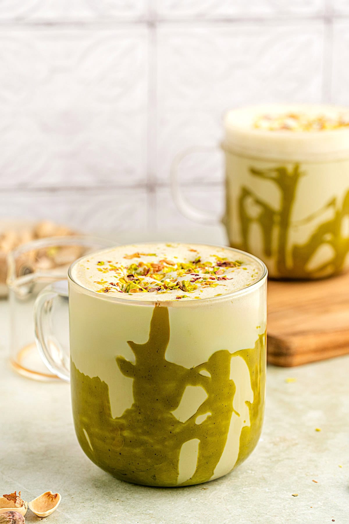 Two pistachio lattes in glass mugs.