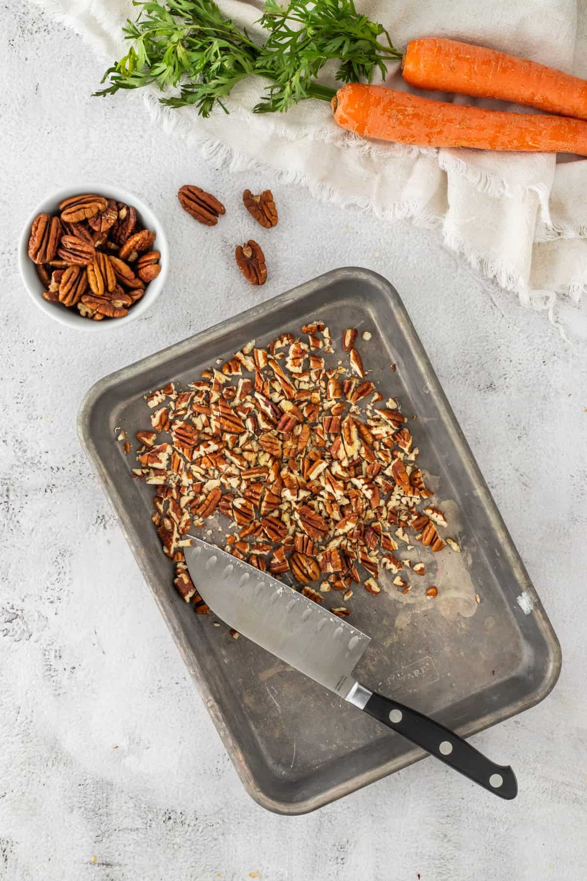 Chopped toasted pecans on a baking sheet.