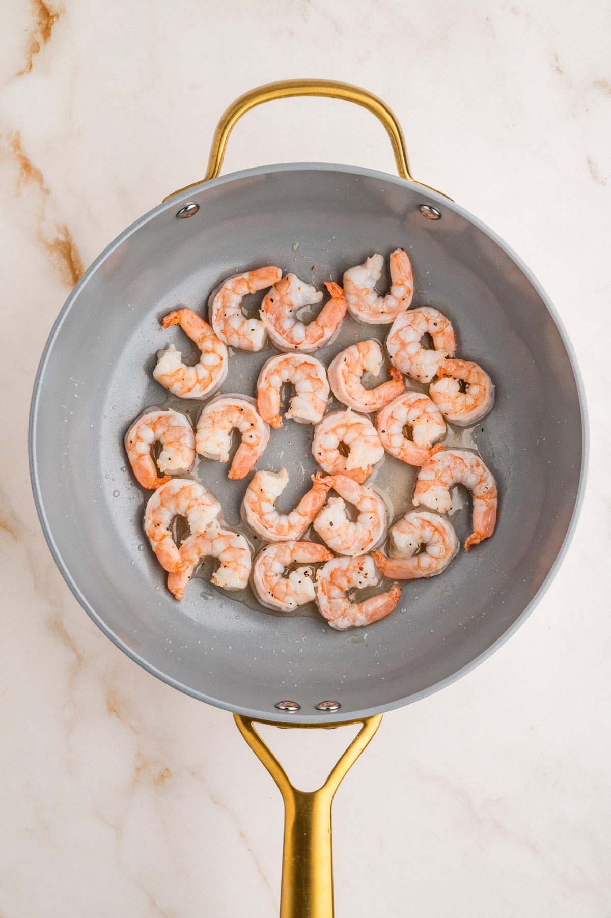 Cooked shrimp in skillet.
