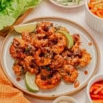 Sweet and spicy shrimp with lime wedges on a plate.
