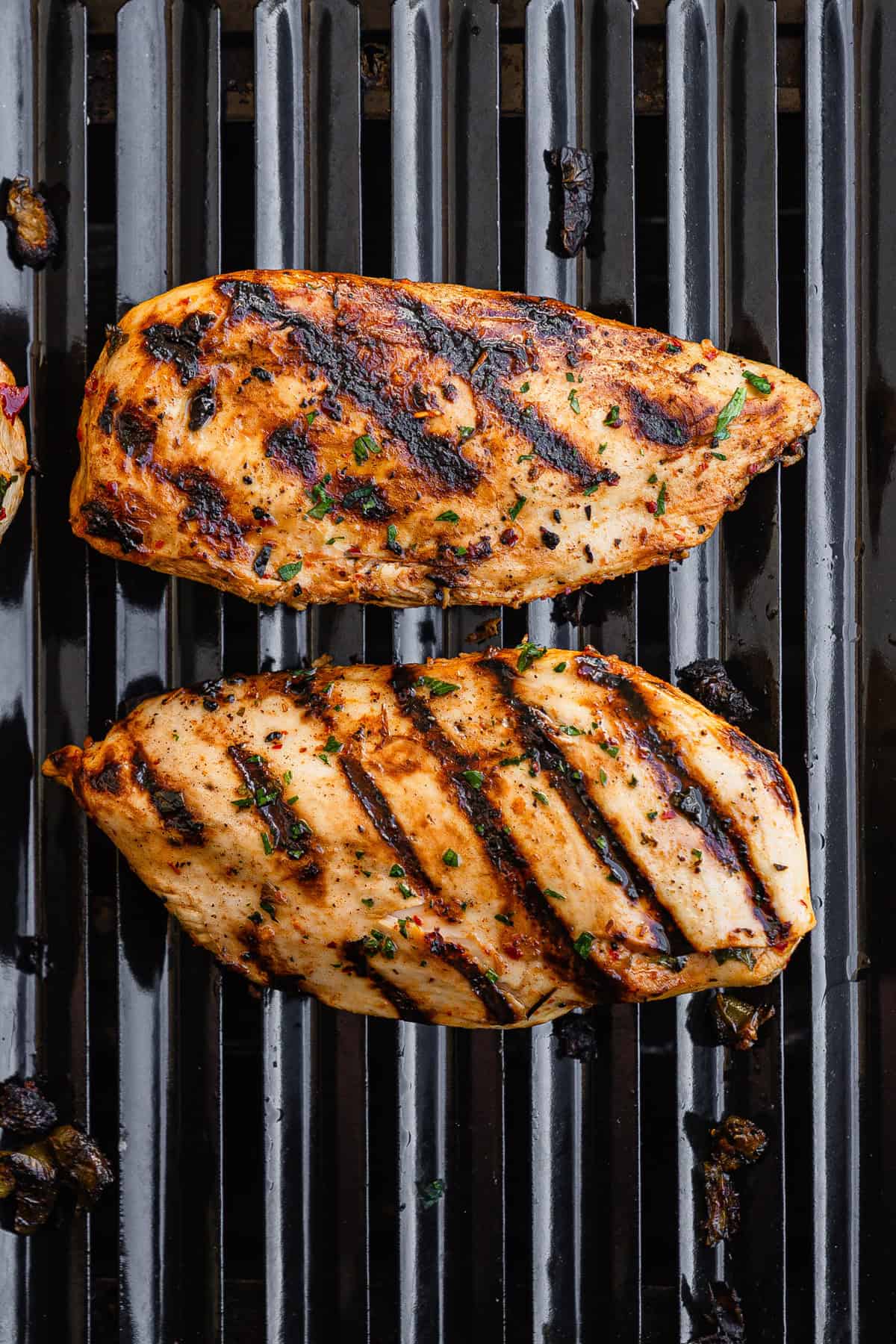 The marinated chicken grilled on both sides on a gas grill.