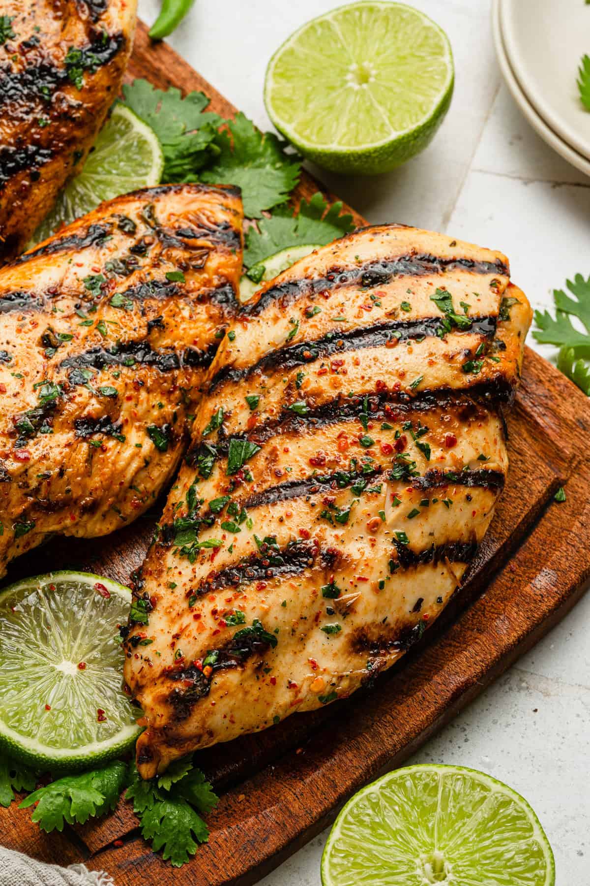 A piece of grilled chicken on a cutting board.
