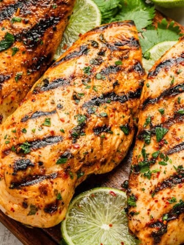 Cilantro lime green chile grilled chicken on a cutting board.