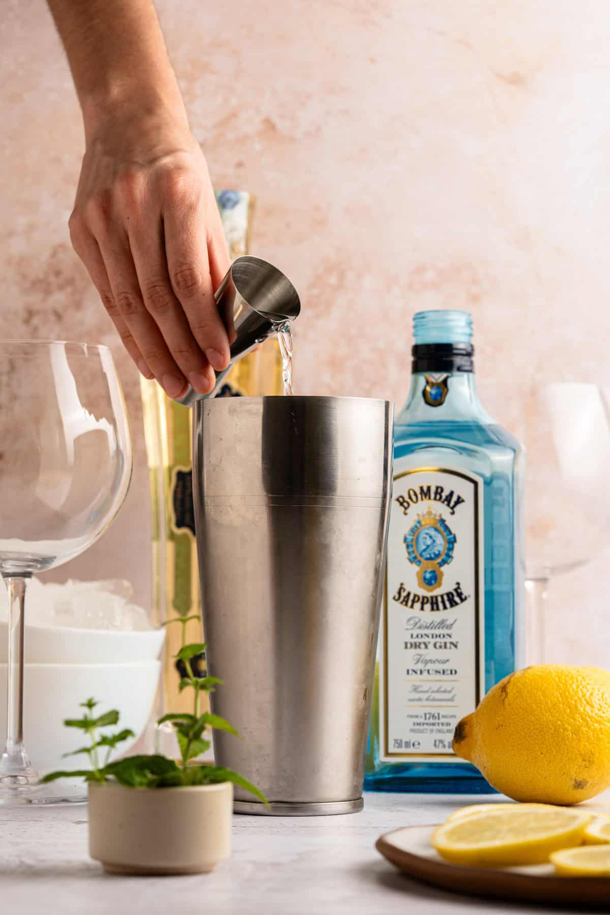 Adding ingredients to a cocktail shaker.